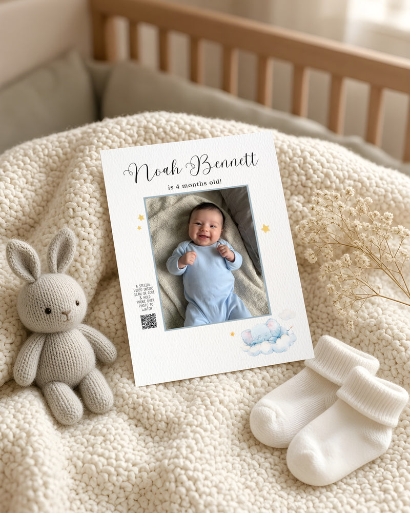 The First Chapter Card with a baby photo, on a knit blanket in a nursery